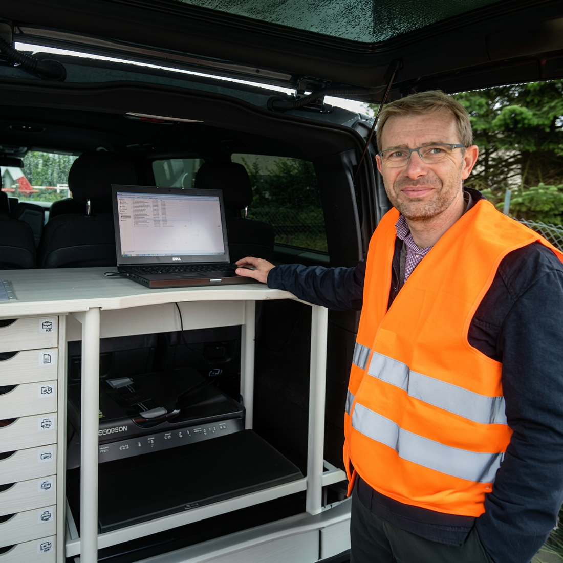 Johann Enns an einem mobilen Arbeitsplatz im Fahrzeug – Laptop, Drucker und Unterlagen, im Einsatz vor Ort